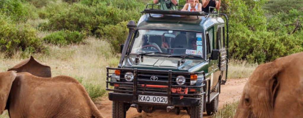 Masai Mara, Kenya, May 19, 2017: Tourists in an all-terrain vehicle exploring the African savannah on safari game drive